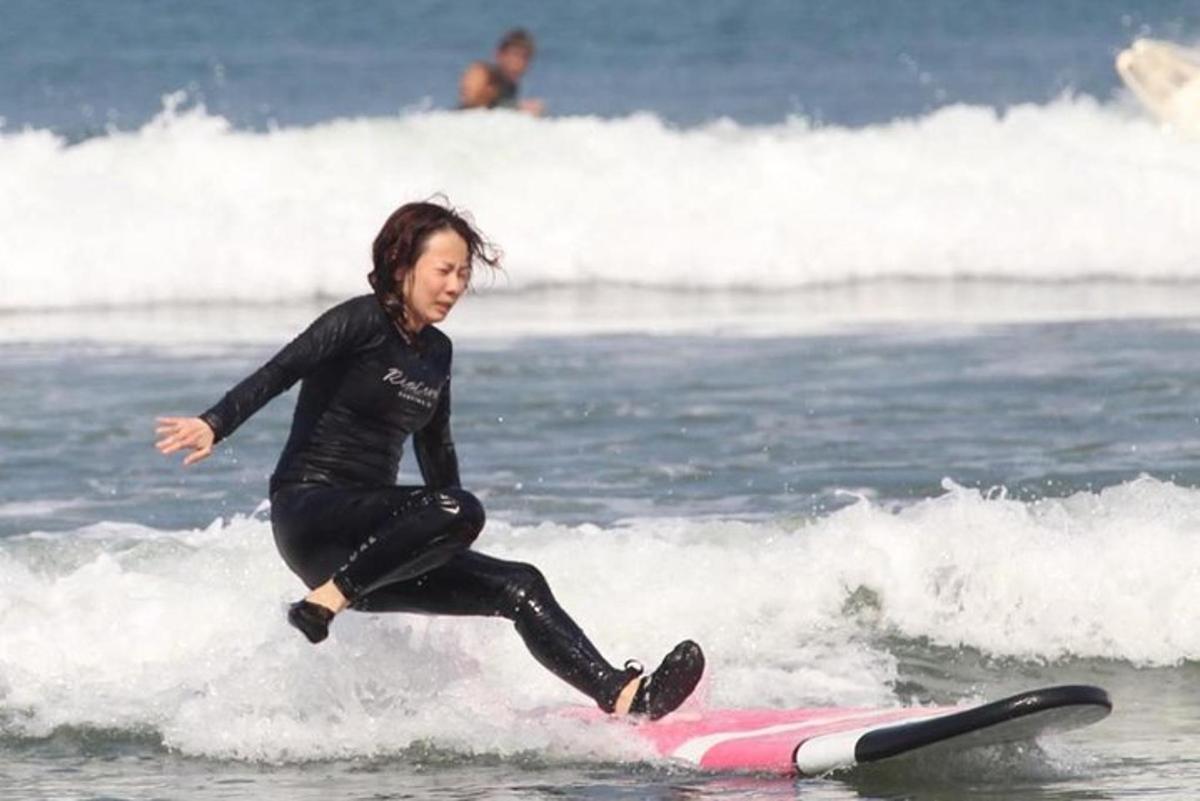 una donna che cavalca un'onda su una tavola da surf nell'oceano