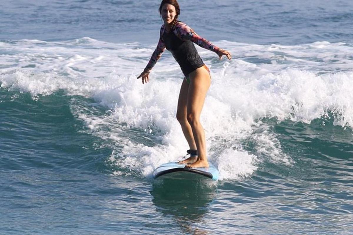 una donna che cavalca un'onda su una tavola da surf nell'oceano