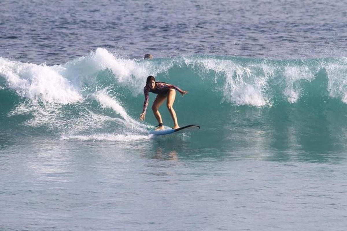 una donna che cavalca un'onda su una tavola da surf nell'oceano