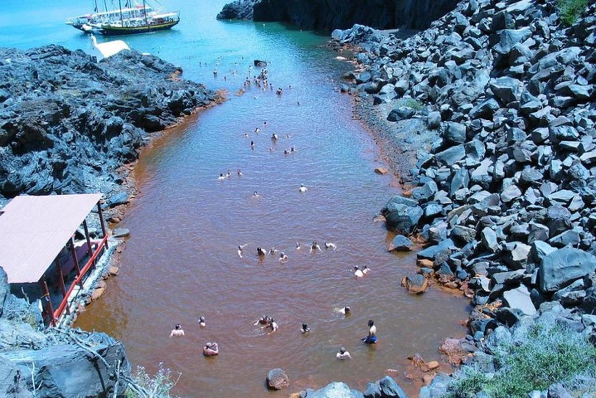 sekumpulan orang berenang di sungai dengan batu