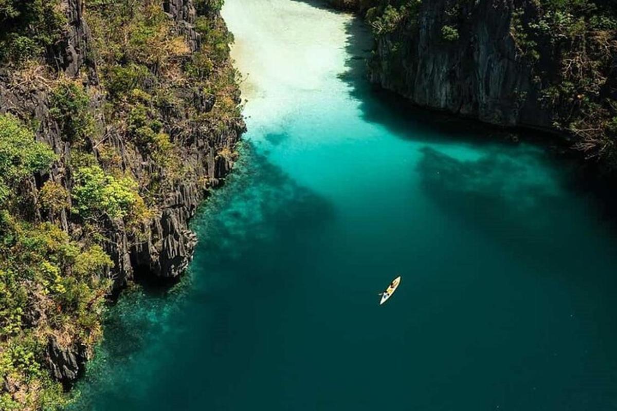 a boat in a river between two cliffs