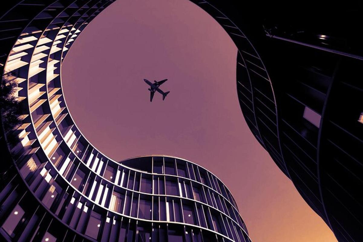 un aereo che vola nel cielo sopra un edificio