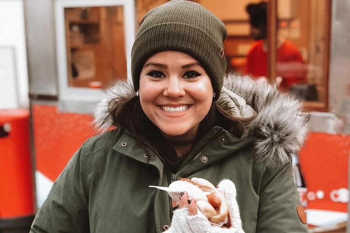 en kvinne som har på seg en hatt og holder en pølse