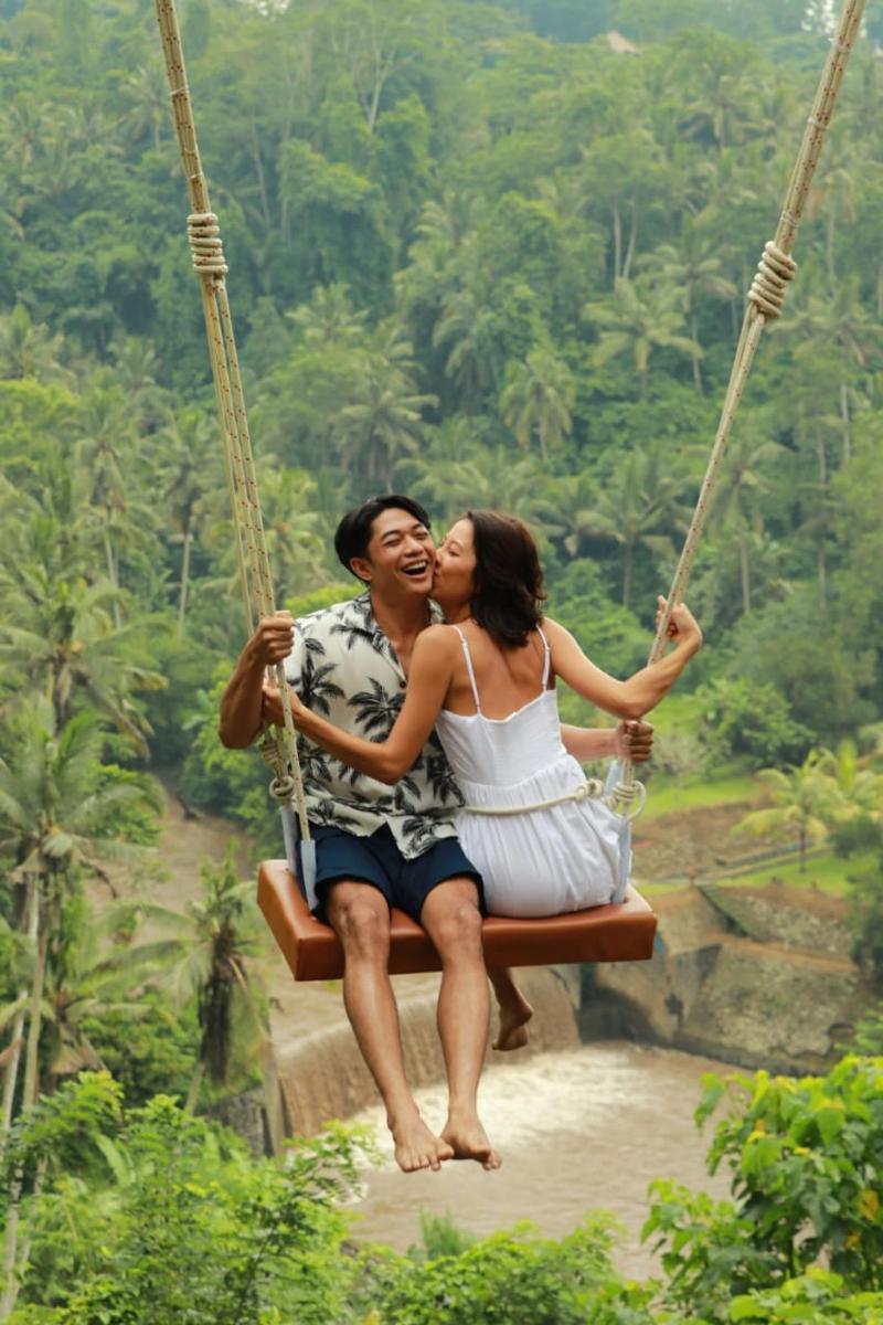 isang lalaki at isang babae na nakaupo sa isang swing