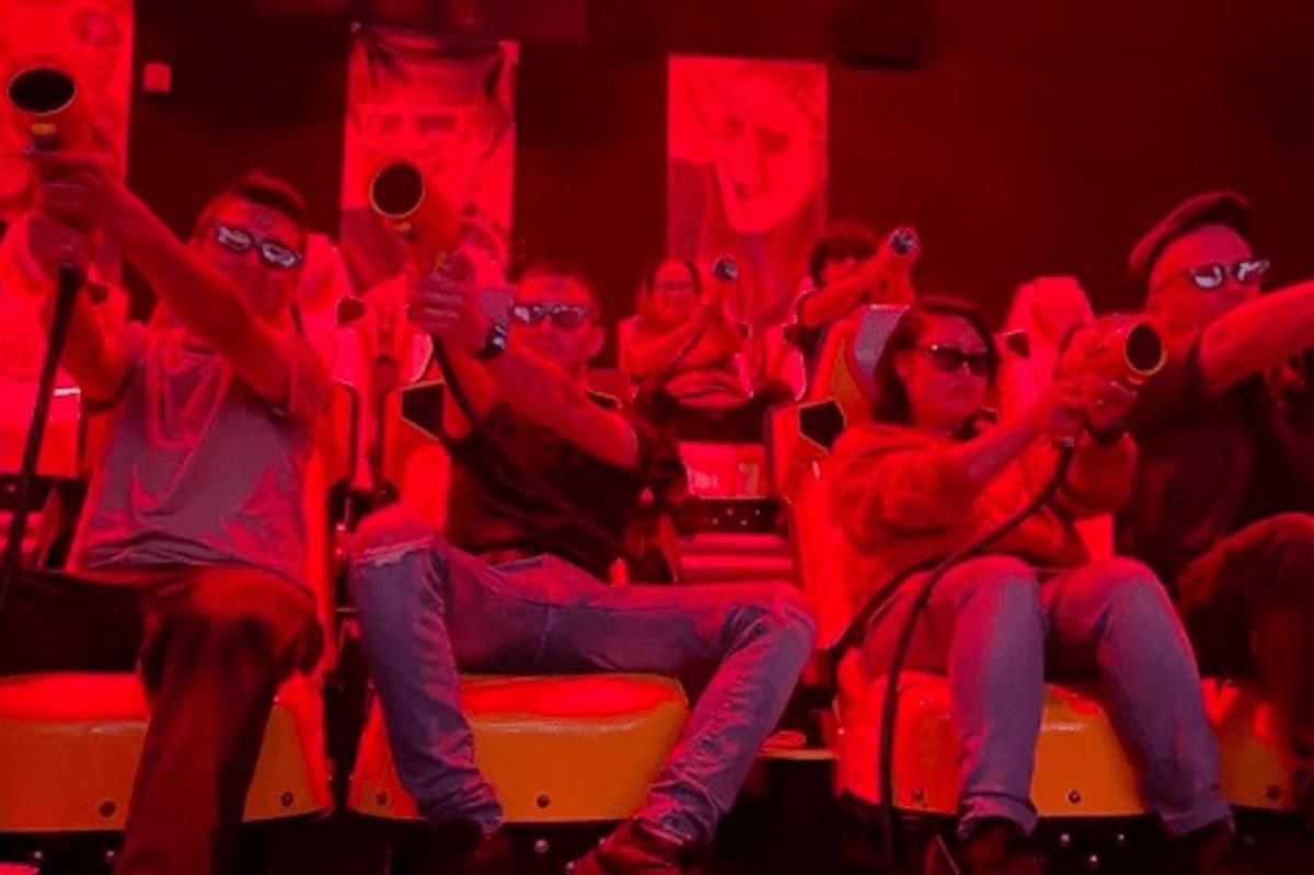 un grup de persones assegudes en un teatre amb llums vermelles