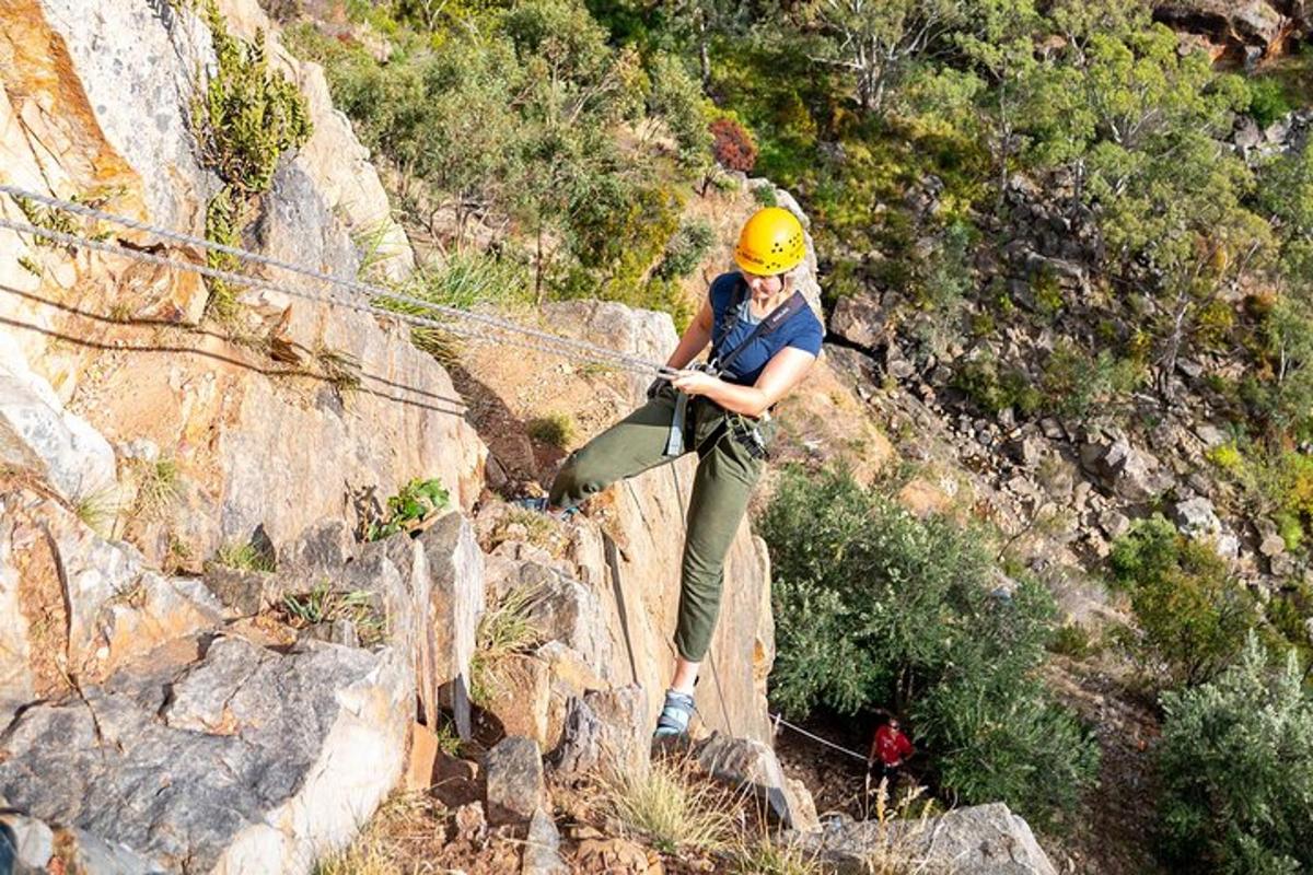 una dona amb un casc groc dempeus sobre una corda