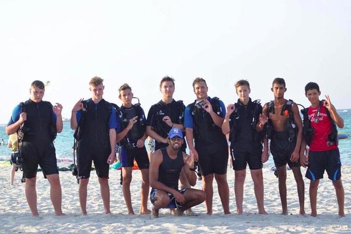 a group of men posing for a picture on the beach