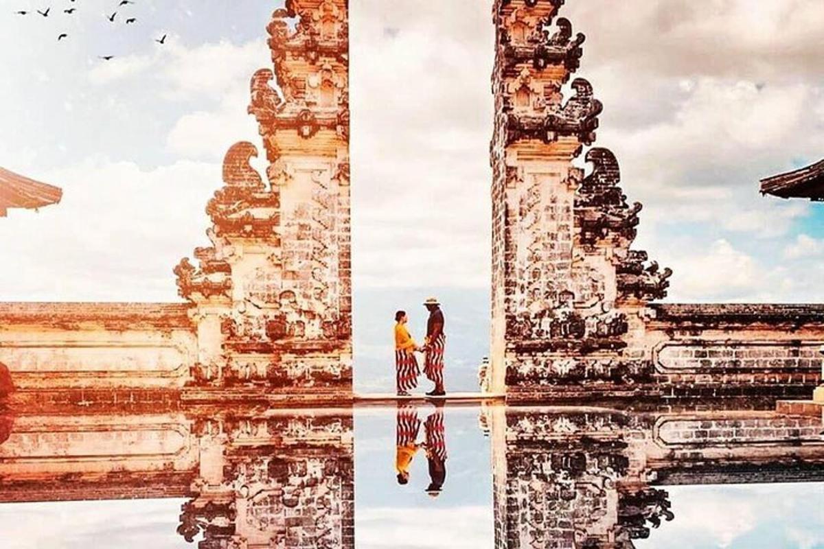 Un hombre parado en el agua frente a un templo.