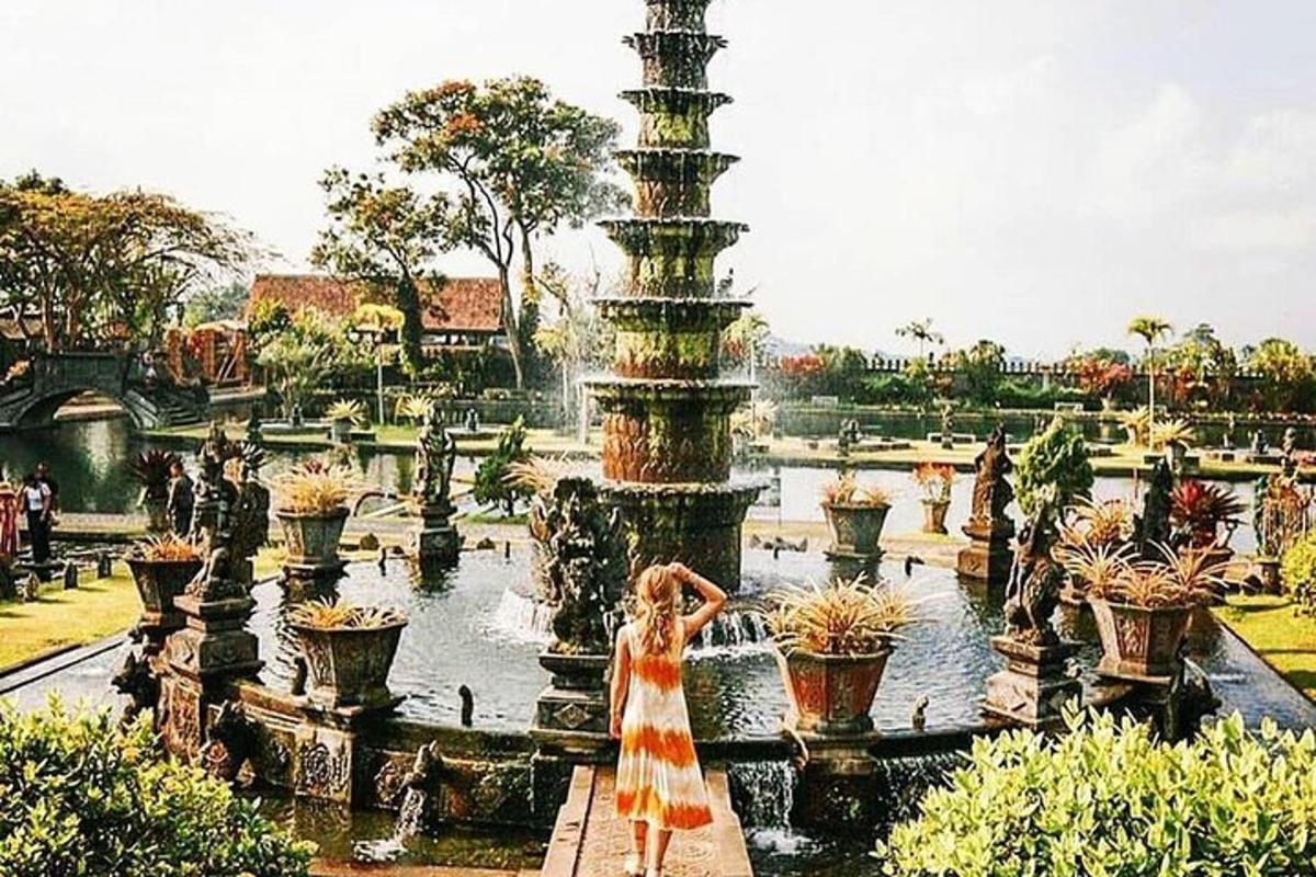 Una mujer con un vestido parada frente a una fuente.