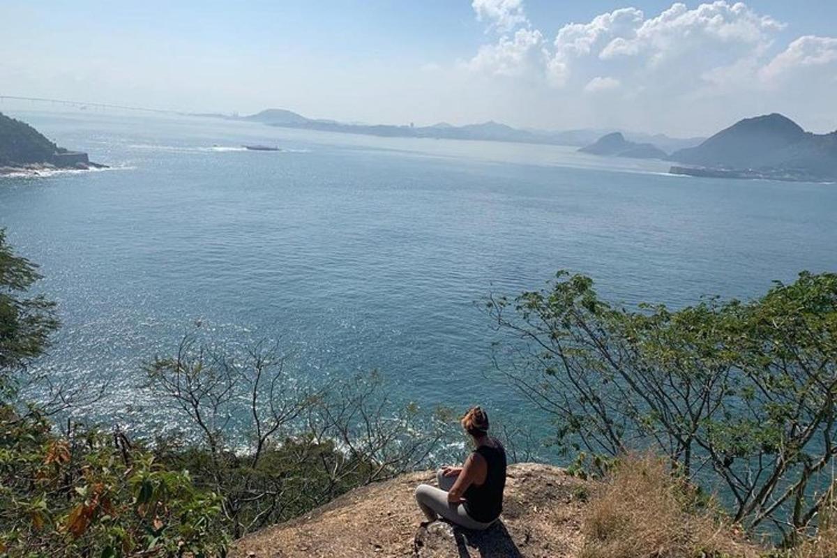 seseorang yang duduk di atas batu melihat air
