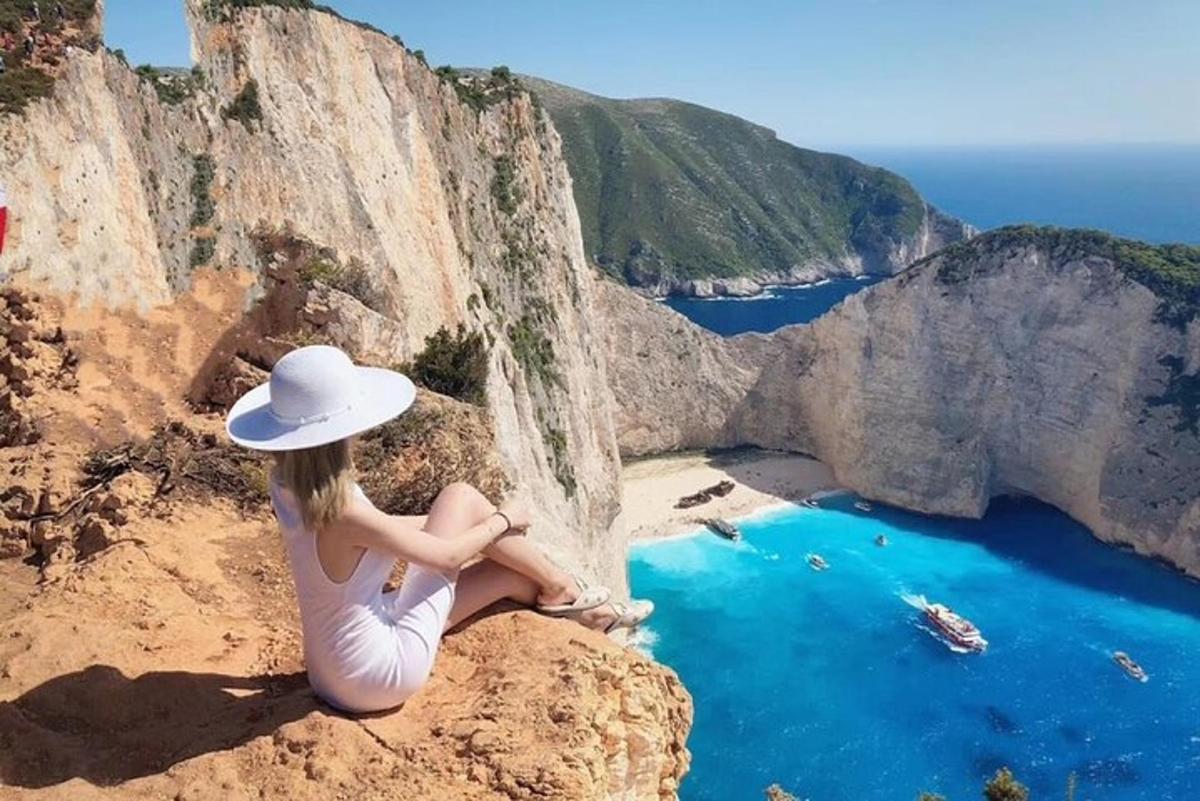žena sedící na útesu a dívající se na oceán