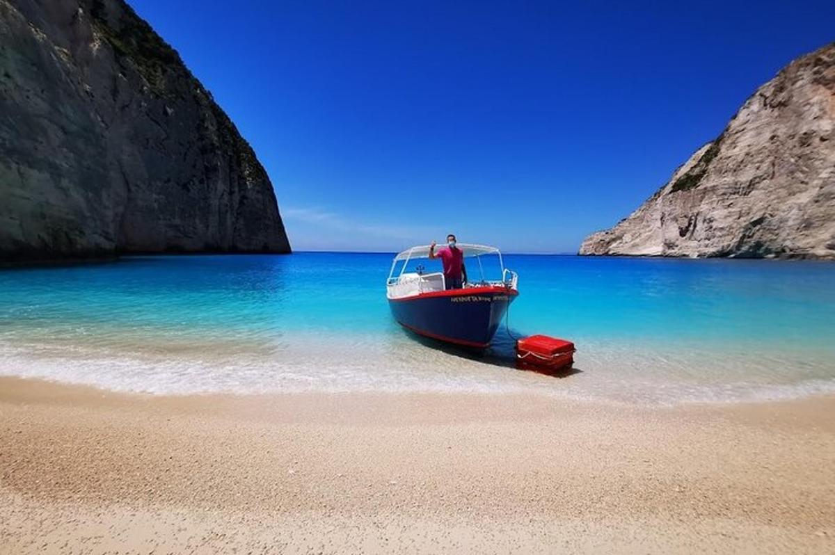 um homem em pé em um barco na praia