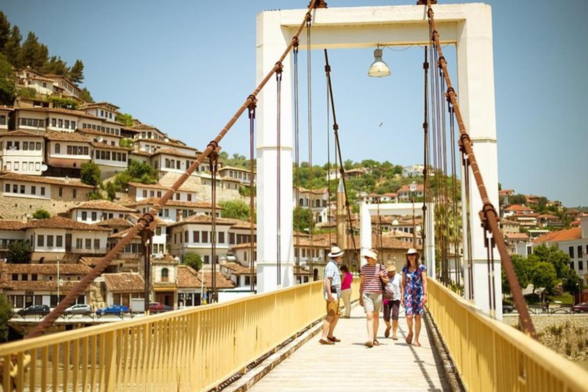 un gruppo di persone che attraversa un ponte su un fiume