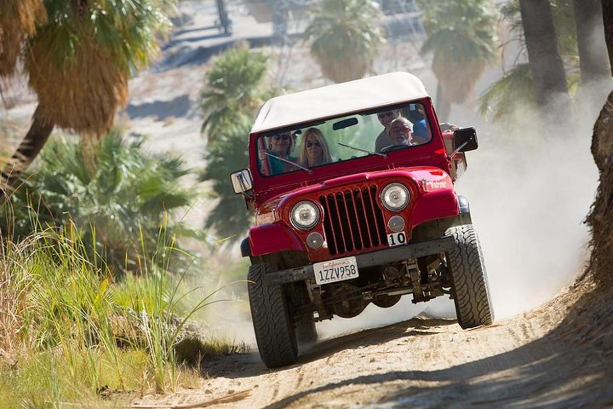 a red jeep driving on a dirt road