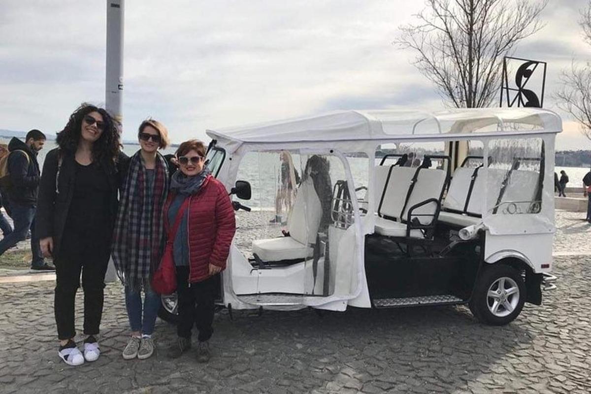 tři ženy stojící vedle bílého golfového vozíku