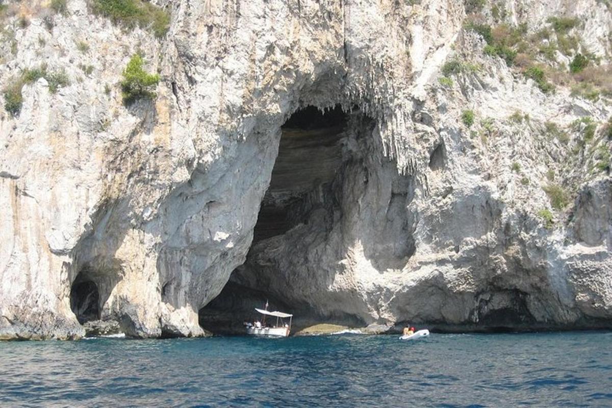 dois barcos na água em frente a uma caverna
