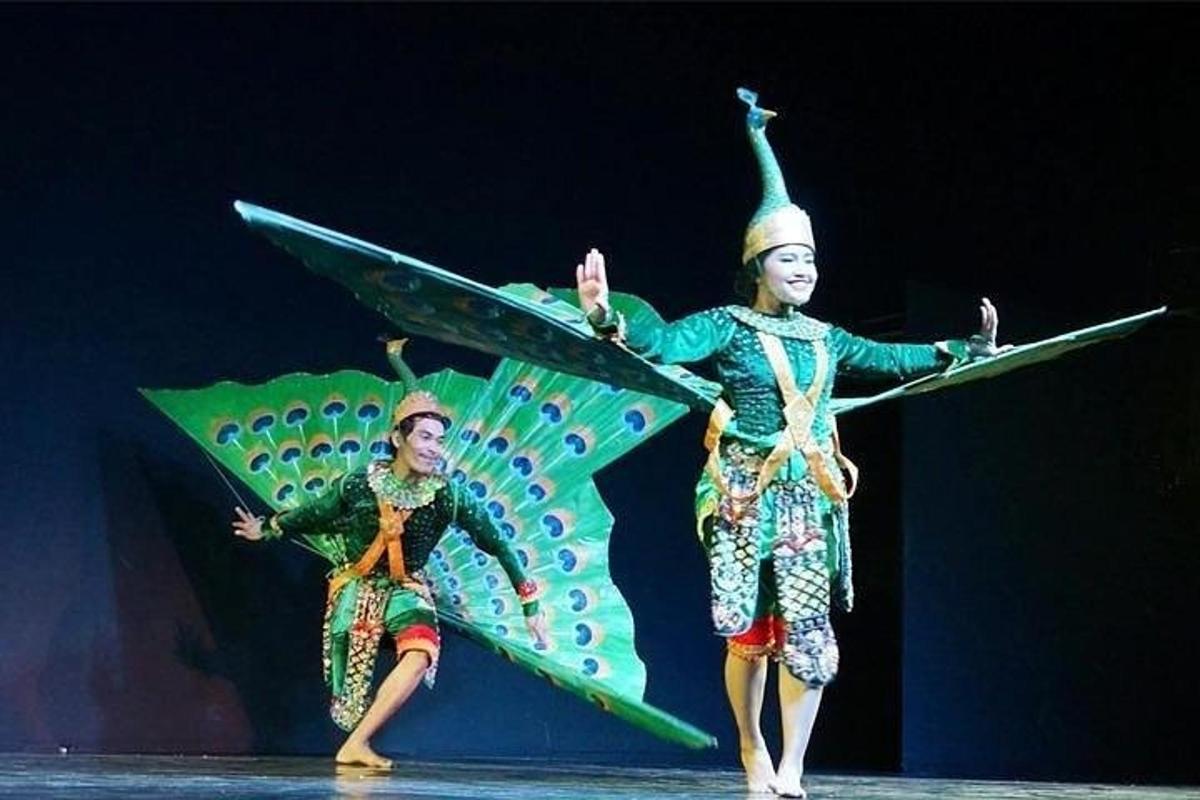 two women performing a dance with a surfboard