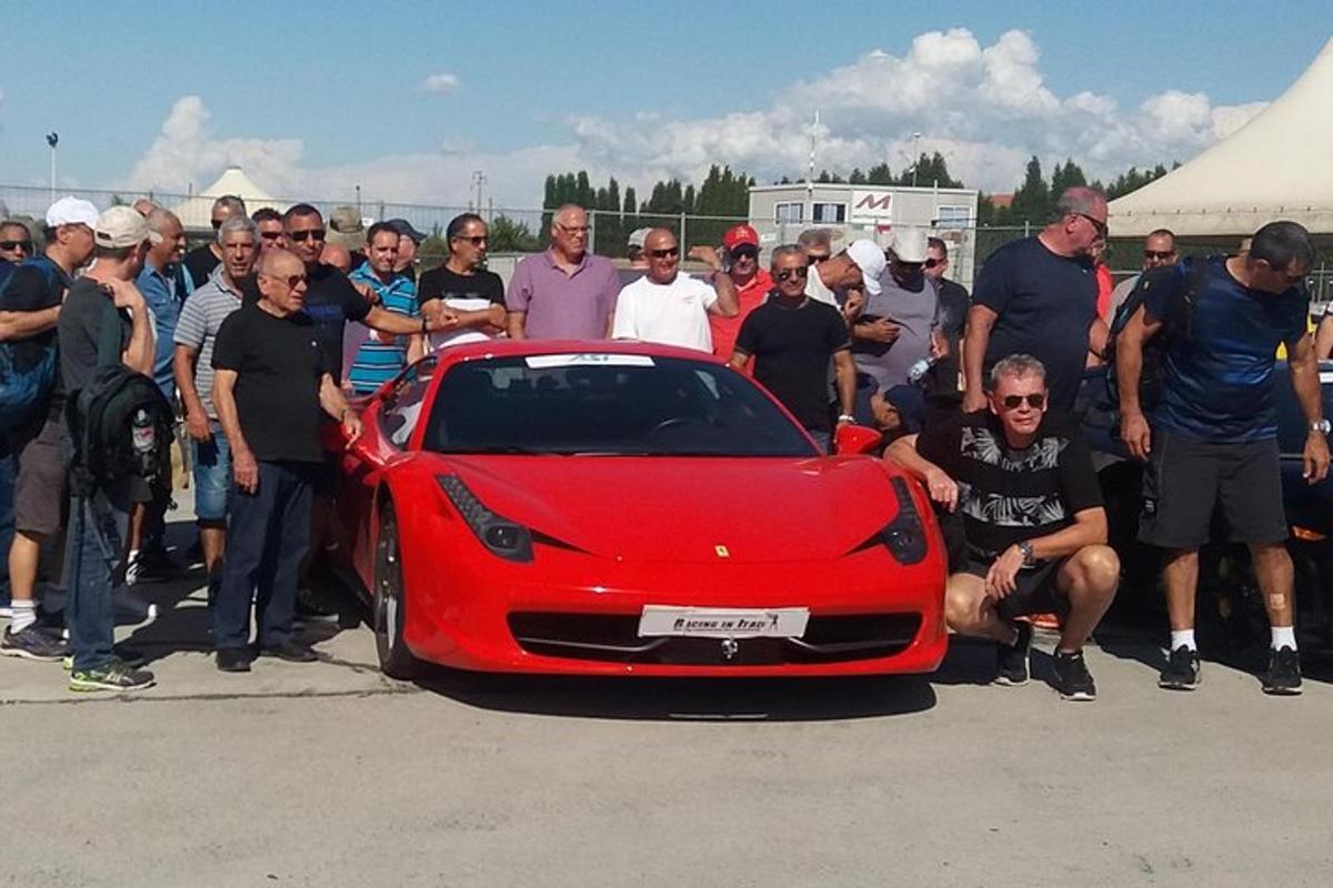 a group of people standing around a red car