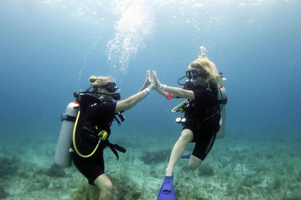 two women giving each other a high five in the ocean