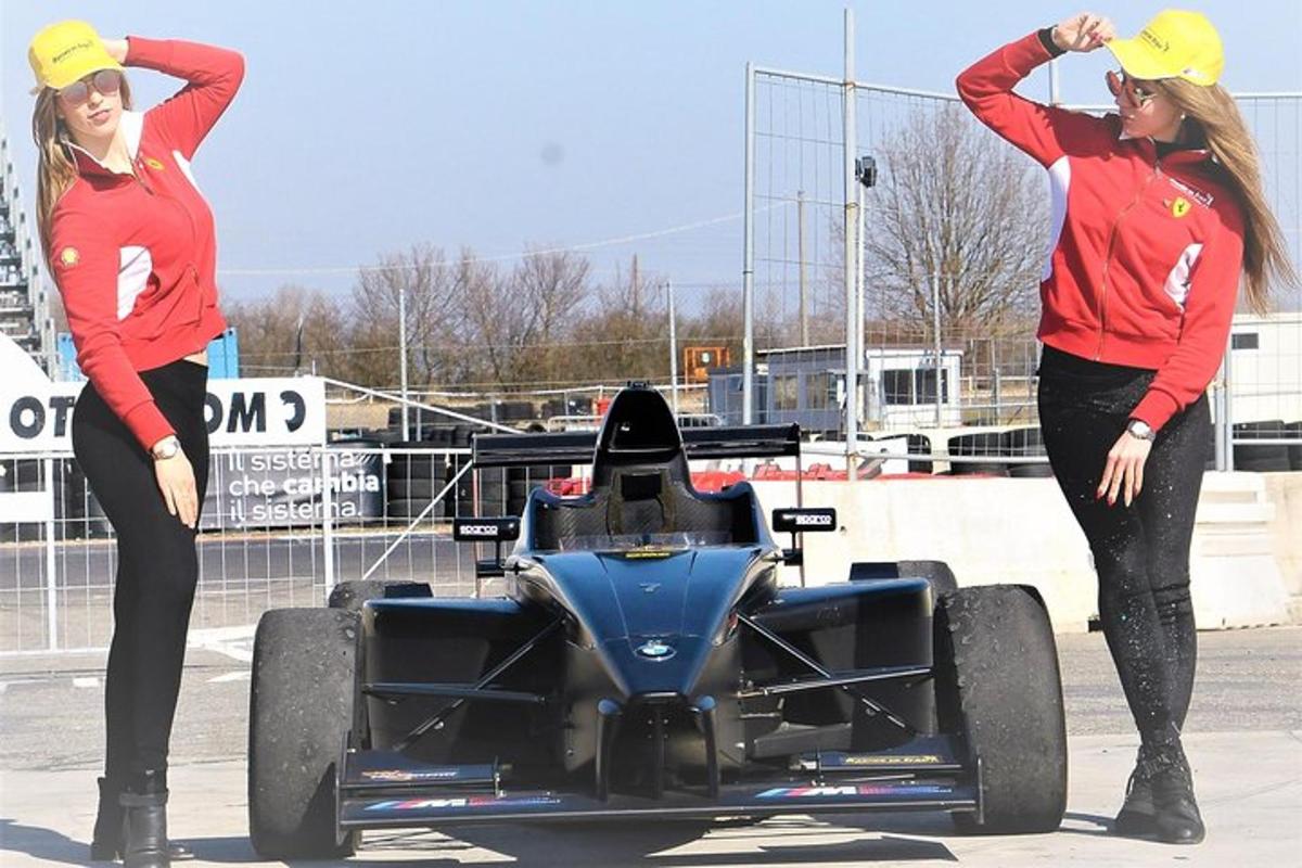 two women standing next to a race car