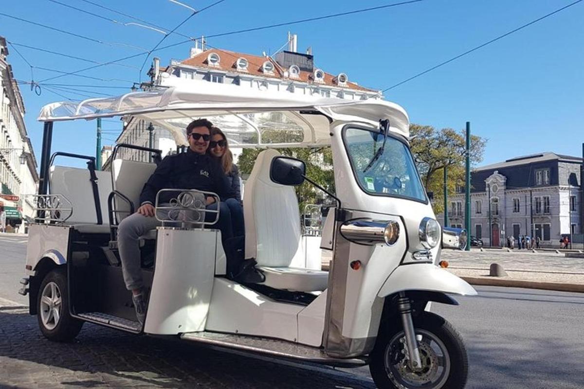 vyras ir moteris važiuoja golfo vežimėliu