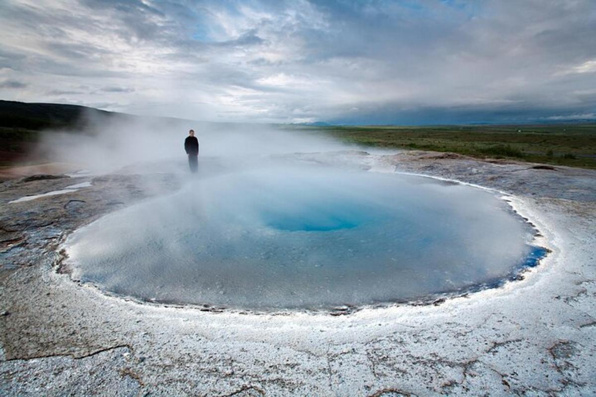 un uomo in piedi davanti a una pozza d'acqua