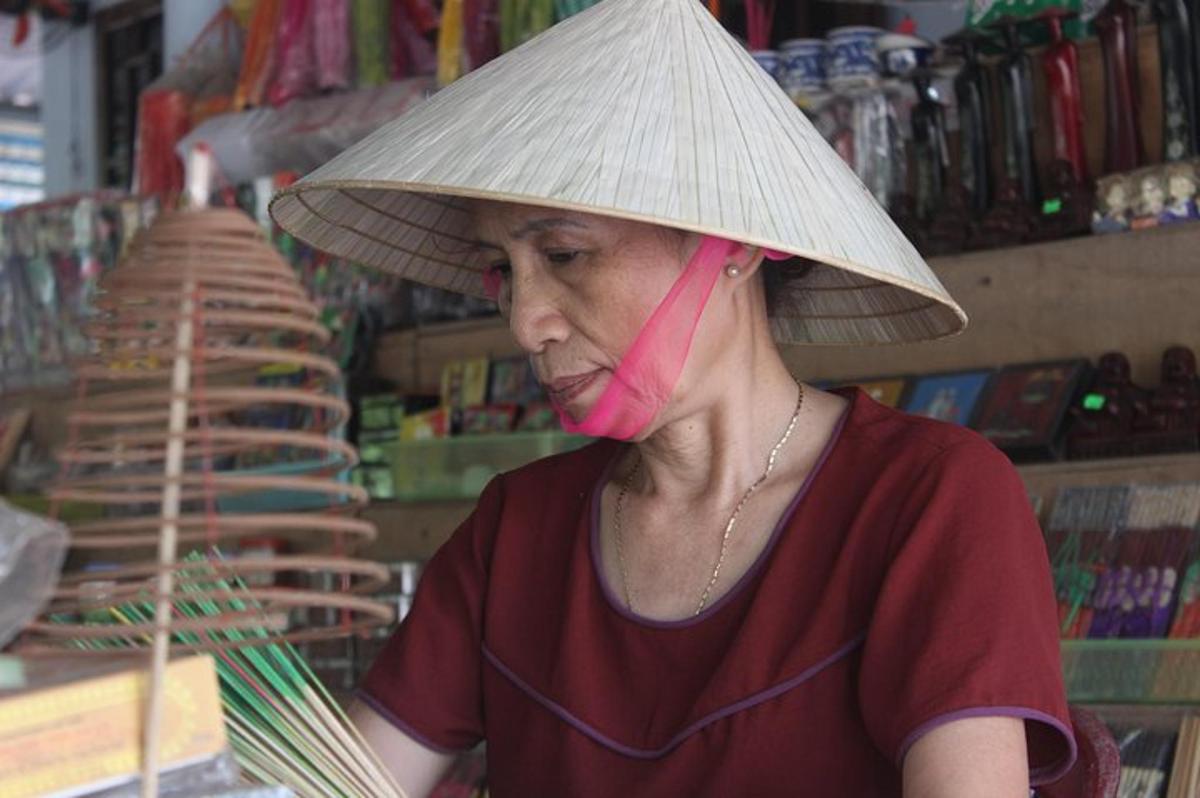 seorang wanita memakai topi jerami dan membuat bakul