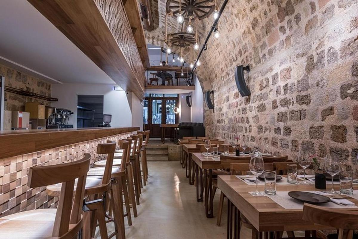 um restaurante com mesas e cadeiras de madeira e uma parede de tijolos