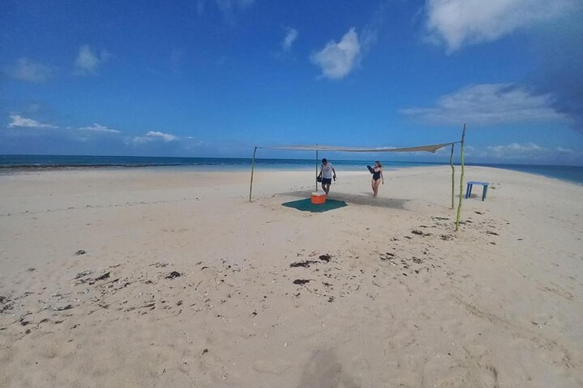 dues persones juguen a futbol a la platja