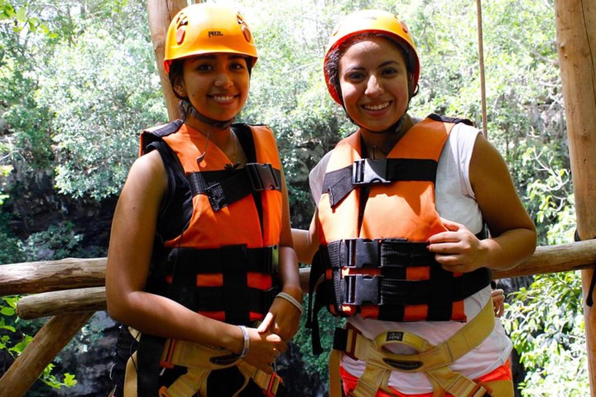 two women in safety gear standing in the forest