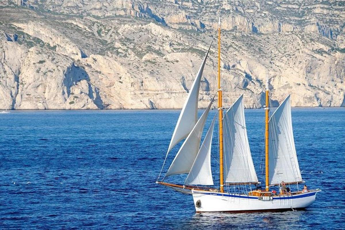 una barca con vele bianche in un grande specchio d'acqua