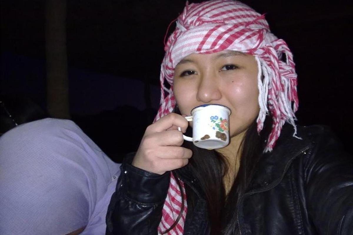 žena v klobouku pije z šálku kávy