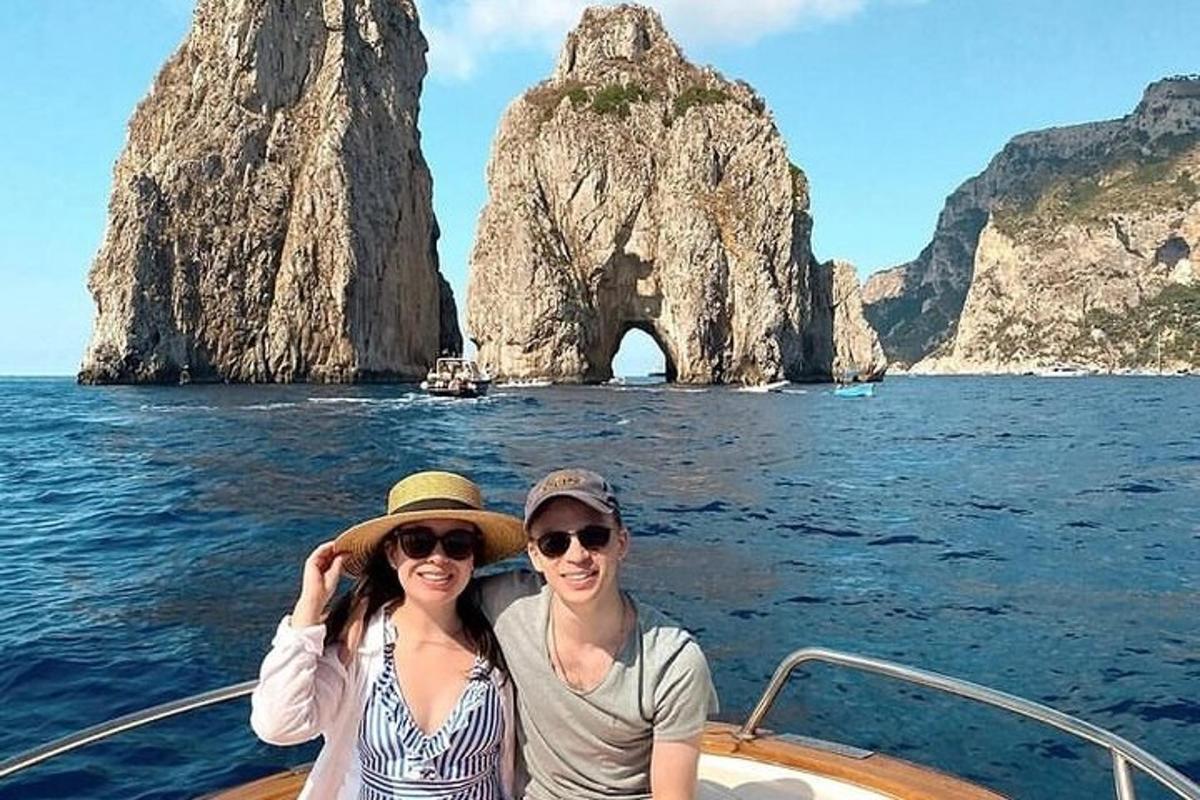 một người đàn ông và một người phụ nữ trên một chiếc thuyền trước một khối đá
