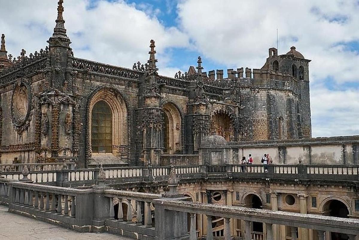 a large building with people standing on a bridge