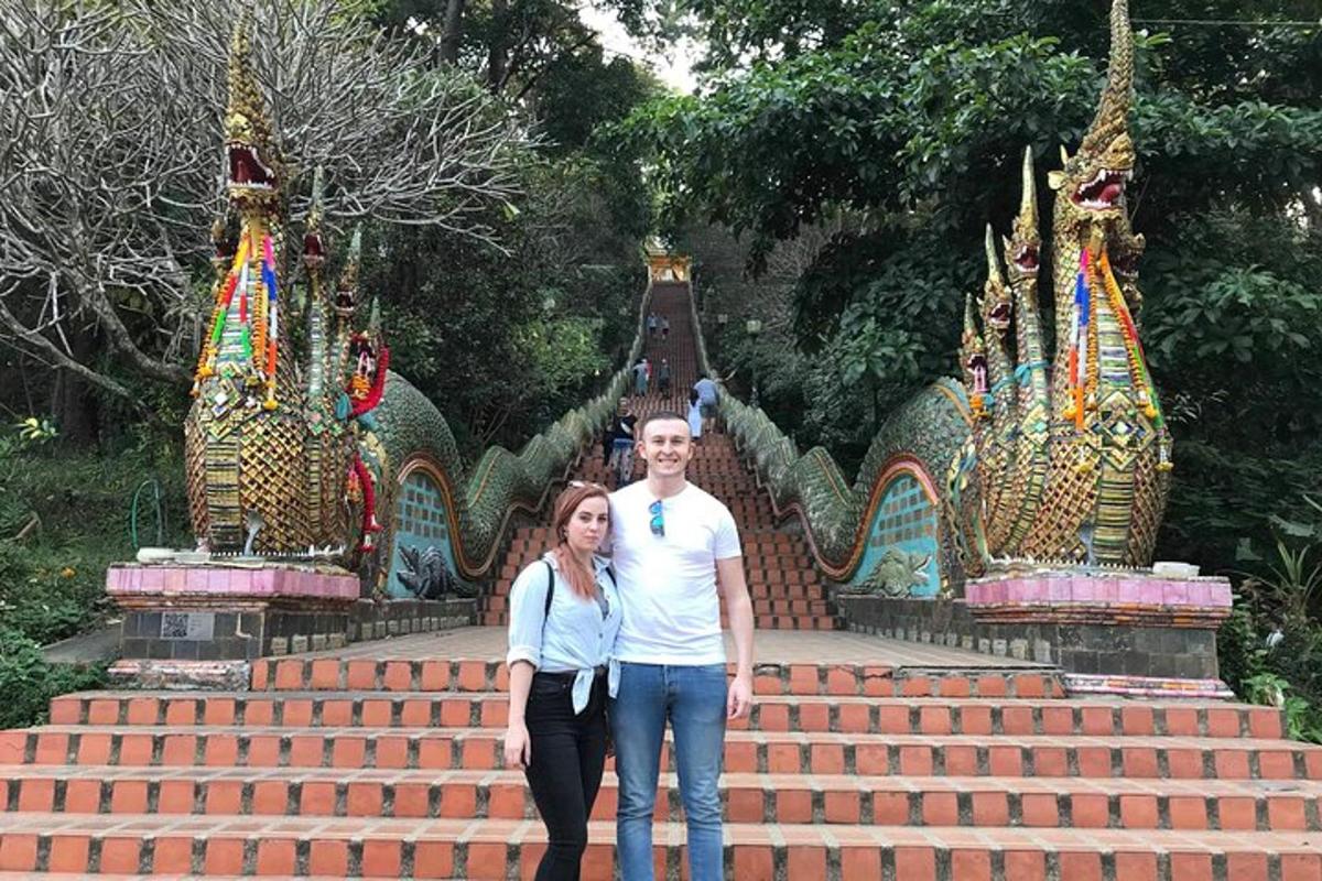 a man and a woman standing in front of some stairs