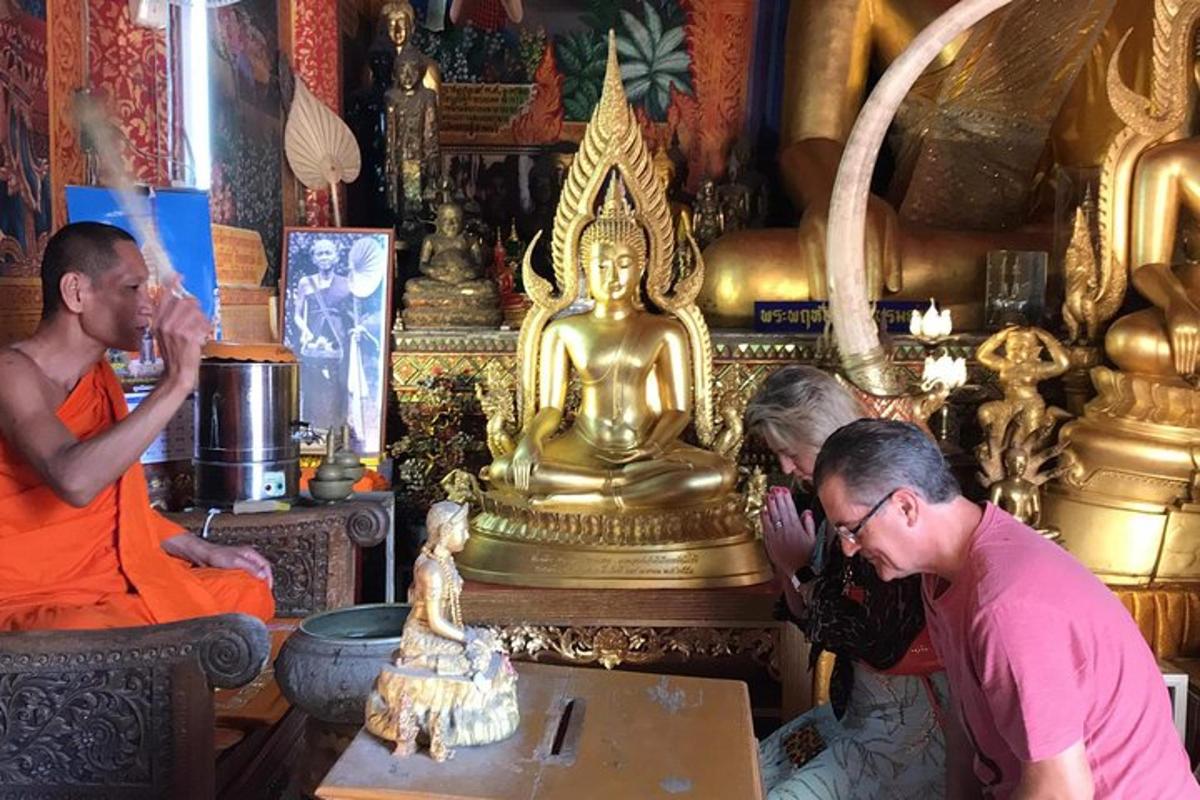 a group of people in a temple with a gold statue