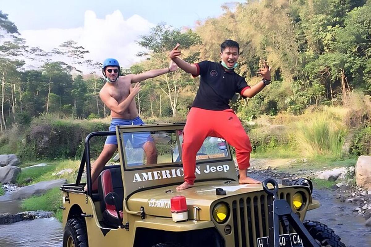 two men standing on the back of a jeep