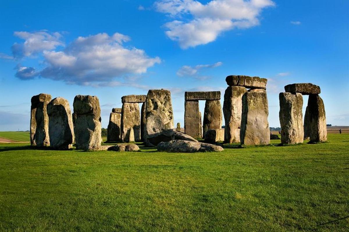 Un antiguo monumento de piedra en un campo con césped verde.
