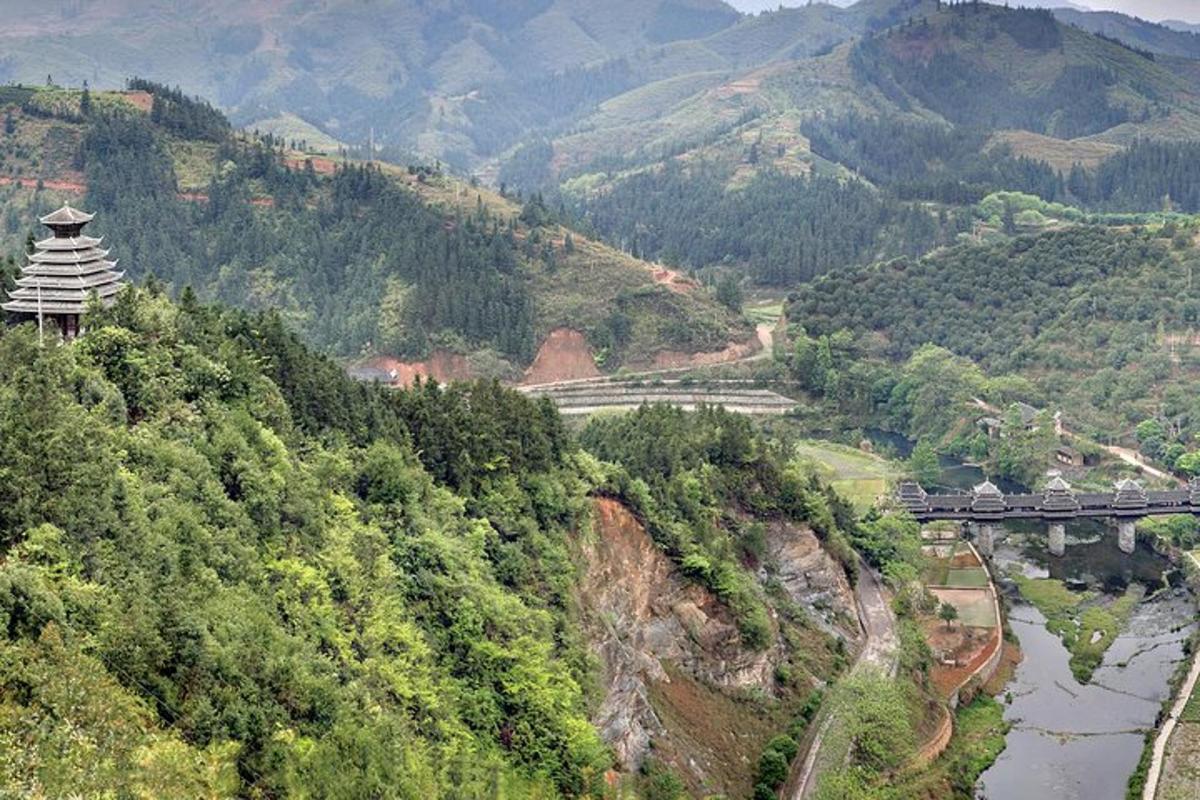 a view of a mountain with a bridge and a train
