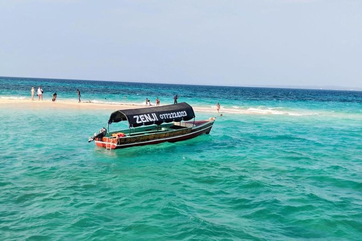 una piccola barca in acqua su una spiaggia