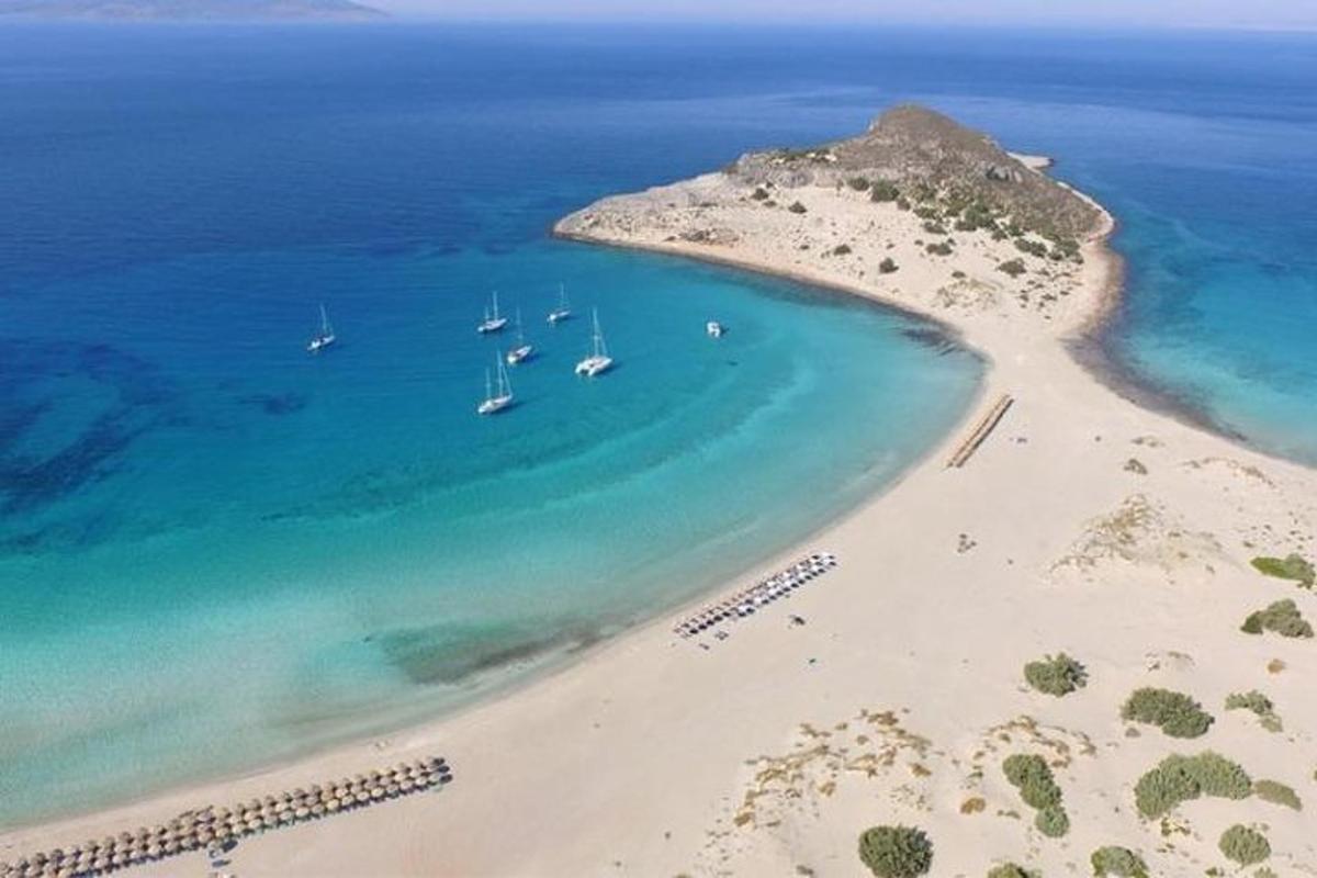 een luchtfoto van een strand met boten in het water