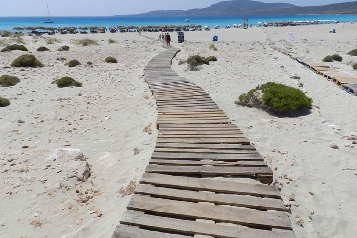 un passeig de fusta en una platja de sorra