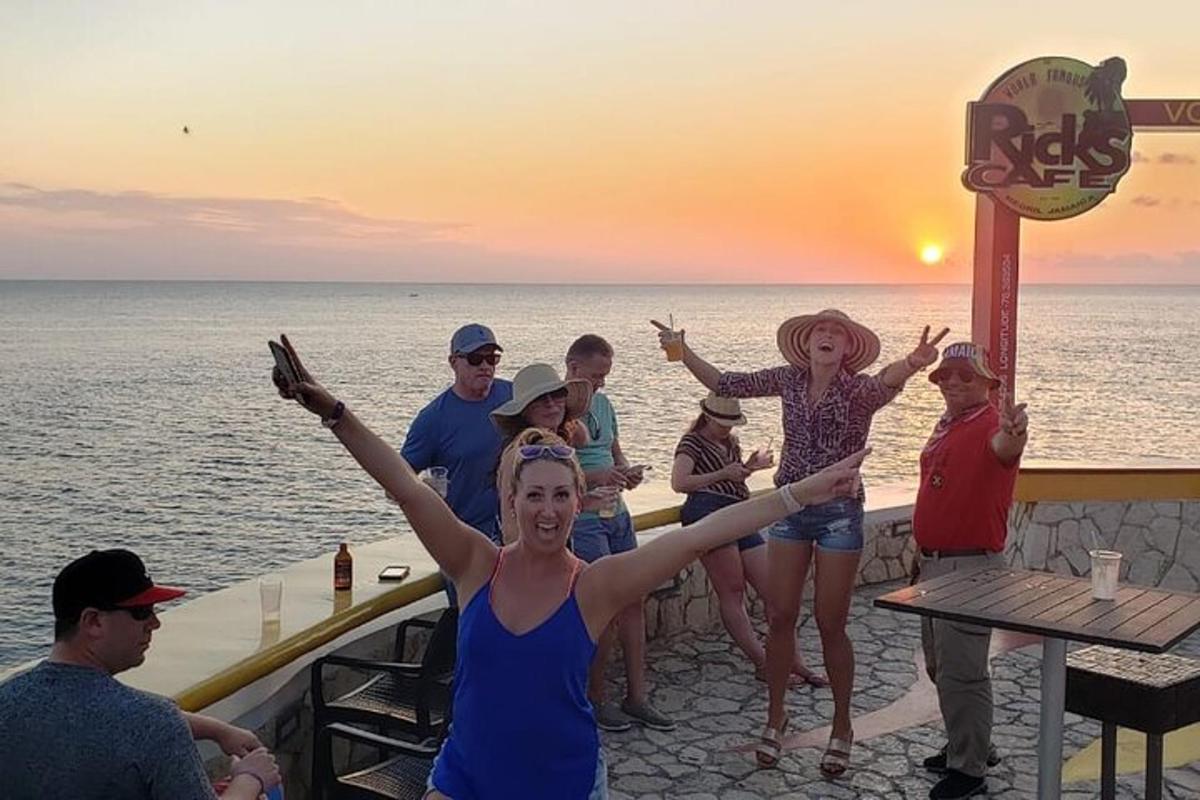 un gruppo di persone in piedi attorno a un bar sull'oceano
