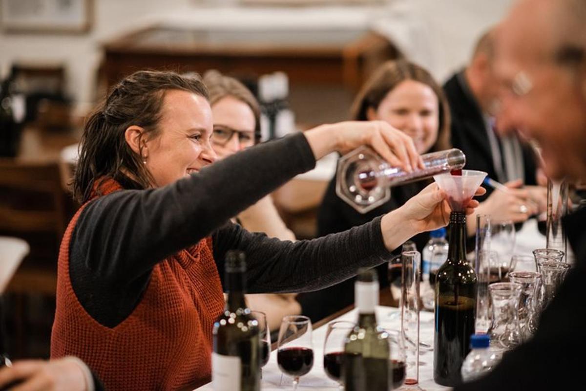 un gruppo di persone sedute a un tavolo che bevono vino