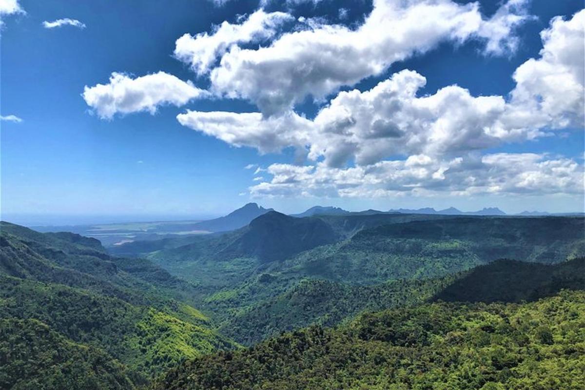 uma vista de um vale com montanhas e nuvens