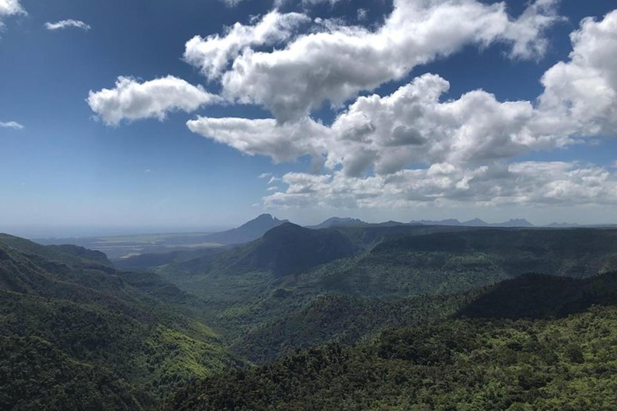 uma vista de um vale com montanhas e nuvens