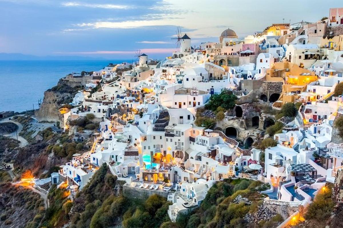 an aerial view of a village on a hill with the ocean