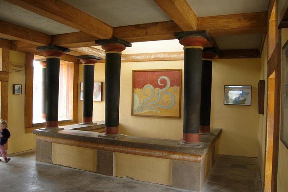 uma sala com colunas e uma pintura na parede