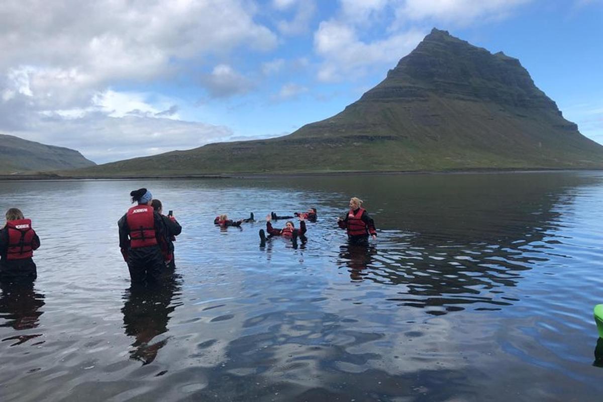 a group of people standing in the water with dogs