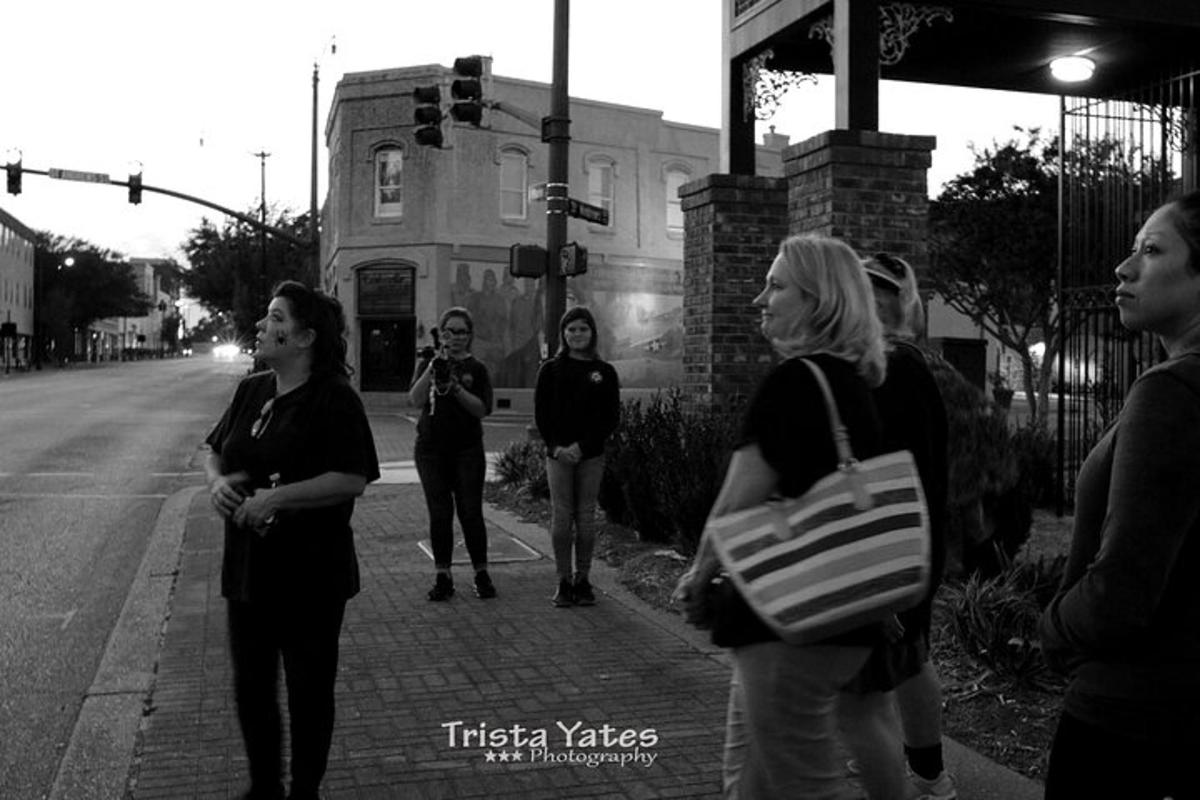 a group of people standing on a street corner